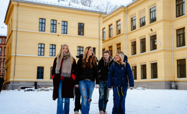 en gruppe mennesker som poserer for et bilde foran en bygning