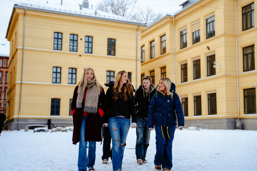 en gruppe mennesker som poserer for et bilde foran en bygning