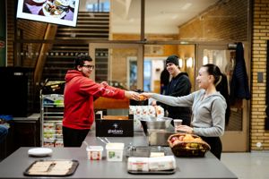 en person og en person serverer mat